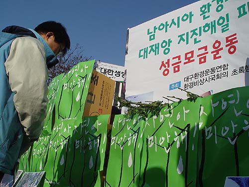 초록행동단은 대구 국채보상운동공원 앞에서 '쓰나미 지진해일 피해 성금 모금운동'을 벌이며 소중한 생명을 잃은 서남아시아 이웃들위해 국화를 헌화하고 있다. 